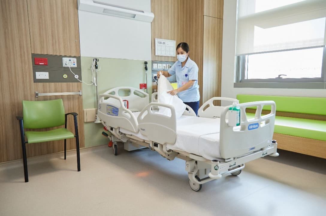Nurse preparing a hospital bed in a medical ward